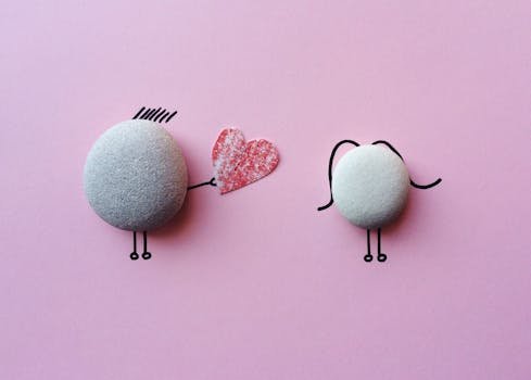 Charming stone art with heart symbol on pink background, symbolizing love and connection.